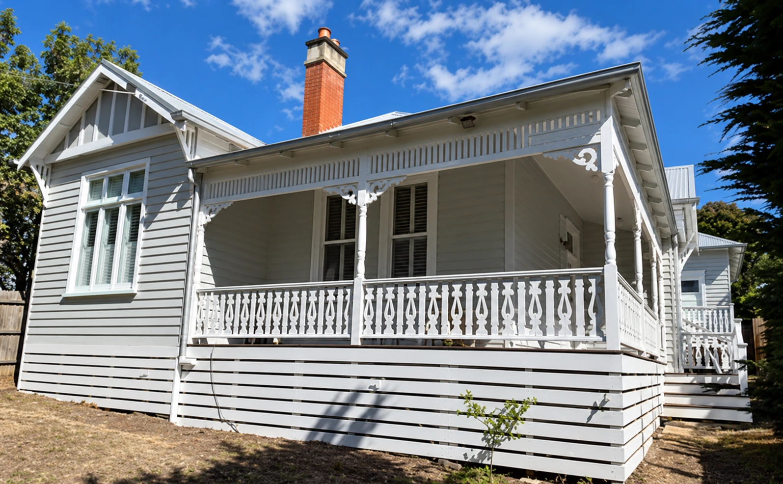 Weatherboard cottage with decorative balustrade; restored photograph